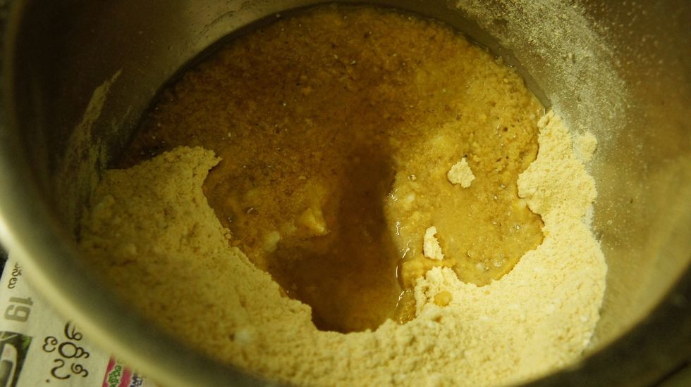 Pour the hot ghee in roasted gram flour and sugar powdered with cardamom...