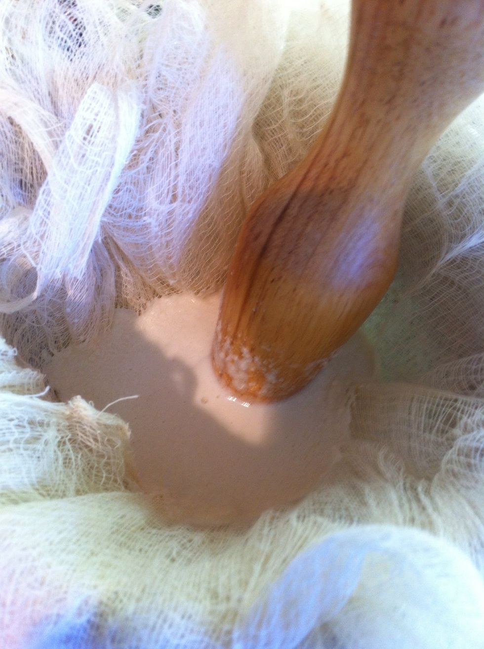 Pour the liquid through a strainer -- I'm using a cheese cloth lined one -- to separate liquid from solids. Do not force as this may push through solids.