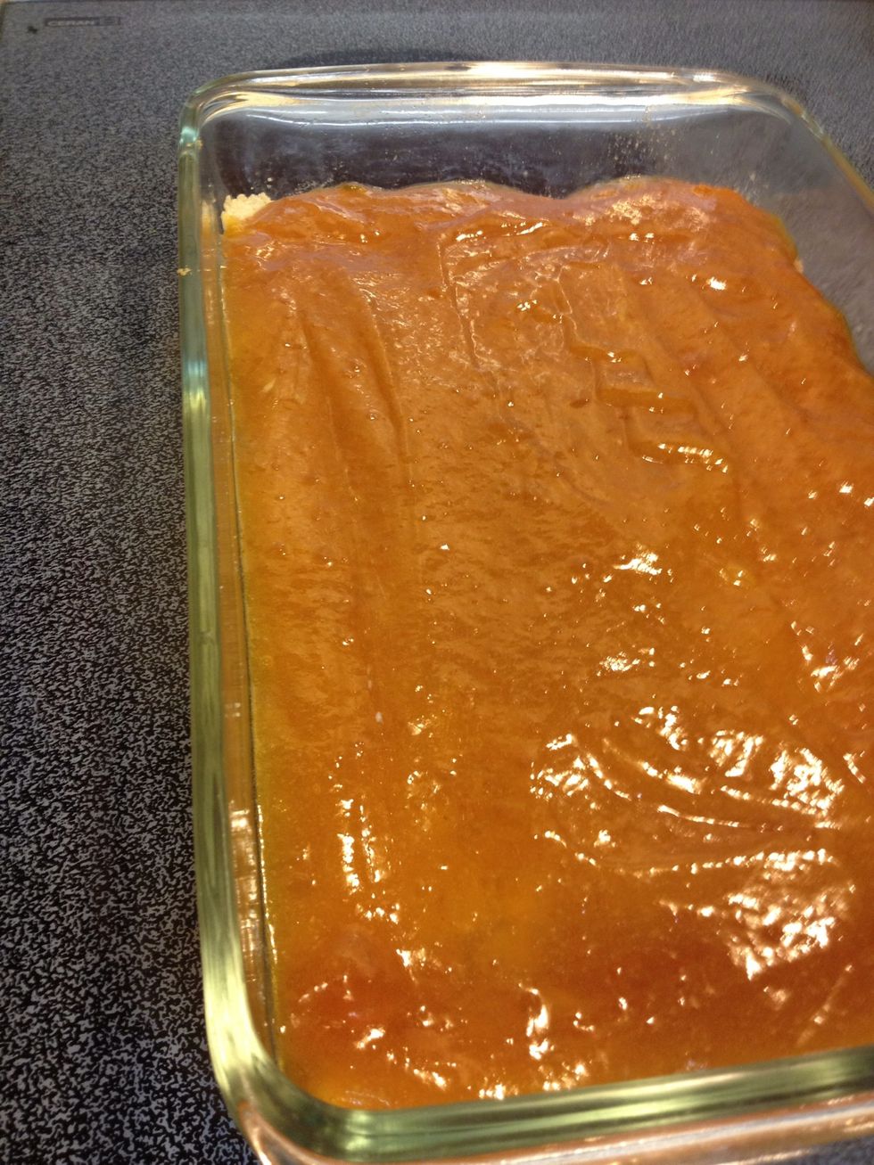 Pour the liquified jam over the hot base. Even out the layer using a spatula or a spoon, and stick back into the oven for 18 mins.