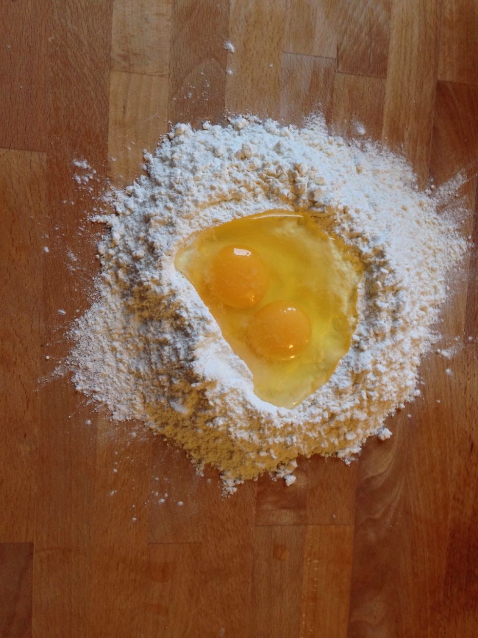 Pour the measured flower on the table and make a hole in the middle. Crack the eggs in the middle and knead the mix by adding hot water as needed to have an elastic dough.