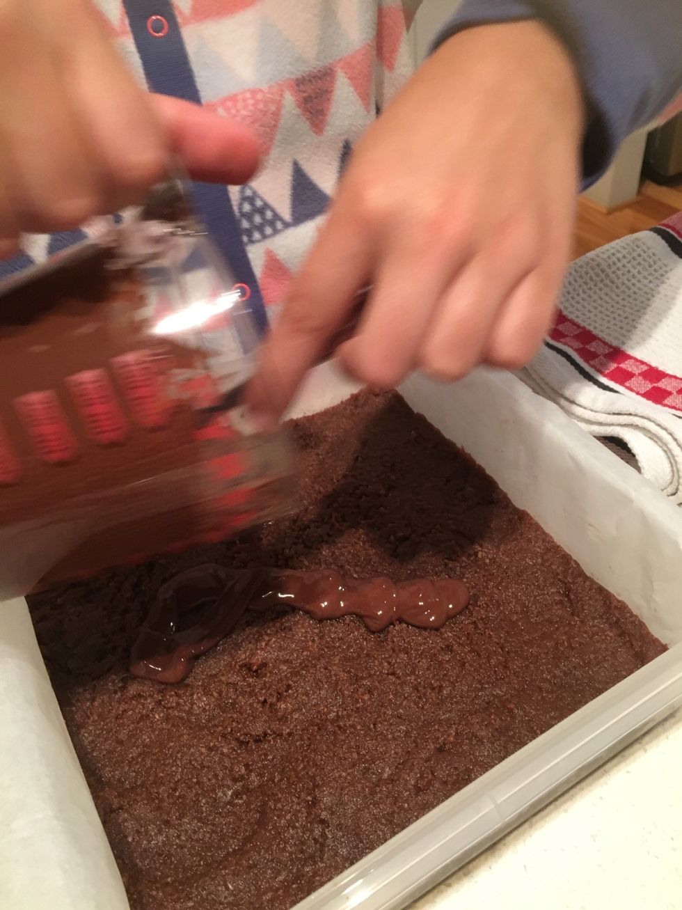 Pour the melted chocolate onto the slice.