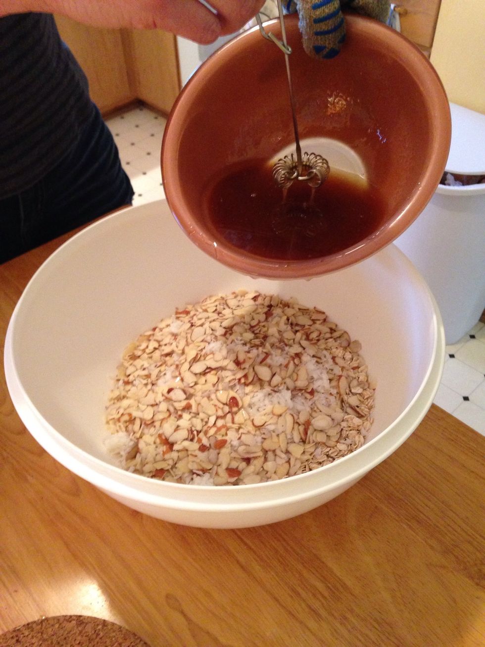Pour the mixture into a bigger bowl with the oats, coconut and almonds.