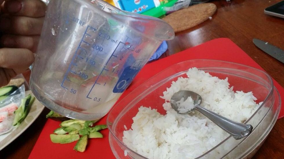 Pour the mixture of the rice vinegar and the sugar over the rice. This is what gives the rice in sushi it's unique flavor.