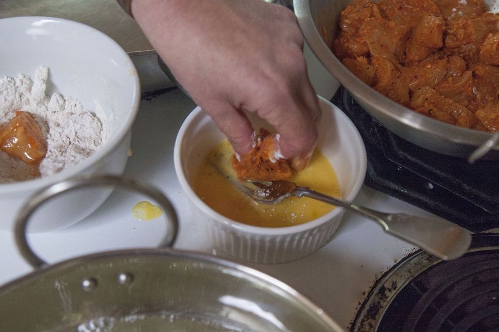 Pour the oil into a deep pot, wok or kadhai. Bring it to 350 degrees. When the oil is hot dip each chicken piece into the egg mixture.