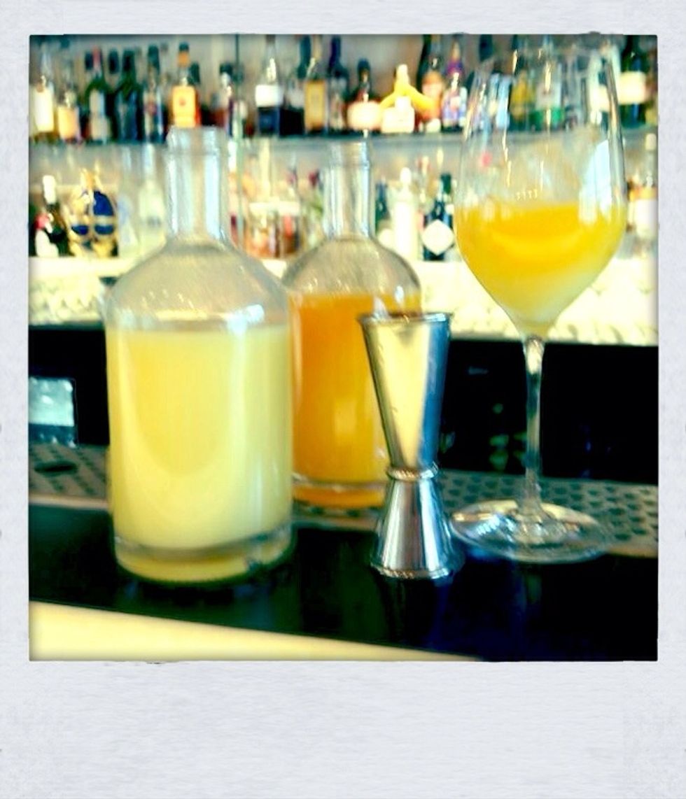 Pour the orange and lemon juice into a wine glass with ice.