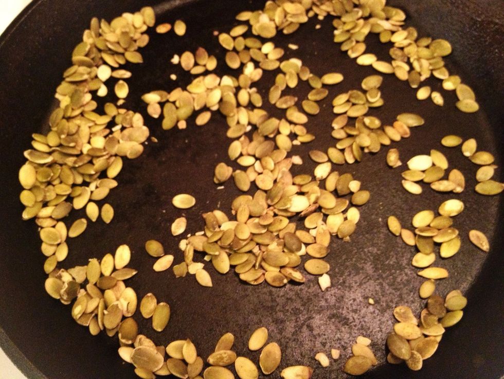 Pour the pumpkin seeds into a skillet on high heat. Roast the seeds..