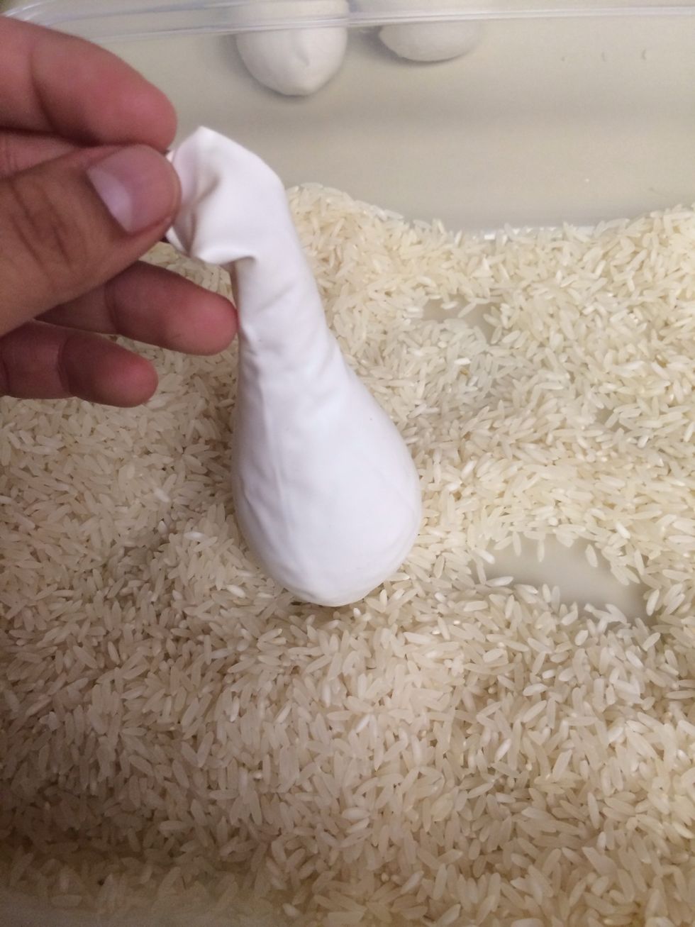 Pour the rice in. It can take several handfuls, and it's okay if it doesn't all go in at once. I've used funnels before, but the rice tends to get stuck in the neck. Fill it up to the neck.