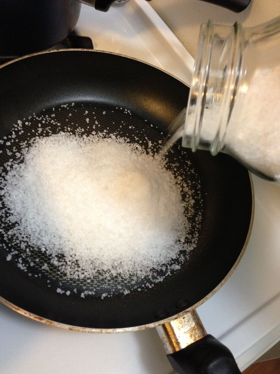 Pour the salt into the pan in medium heat