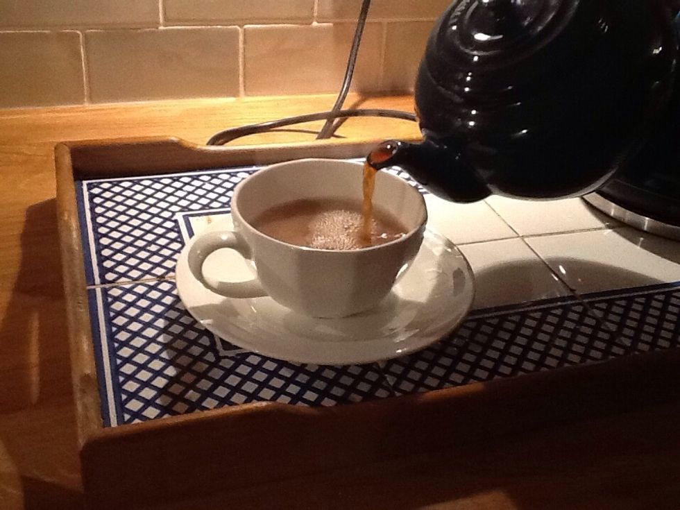 Pour the stirred tea into a cup.