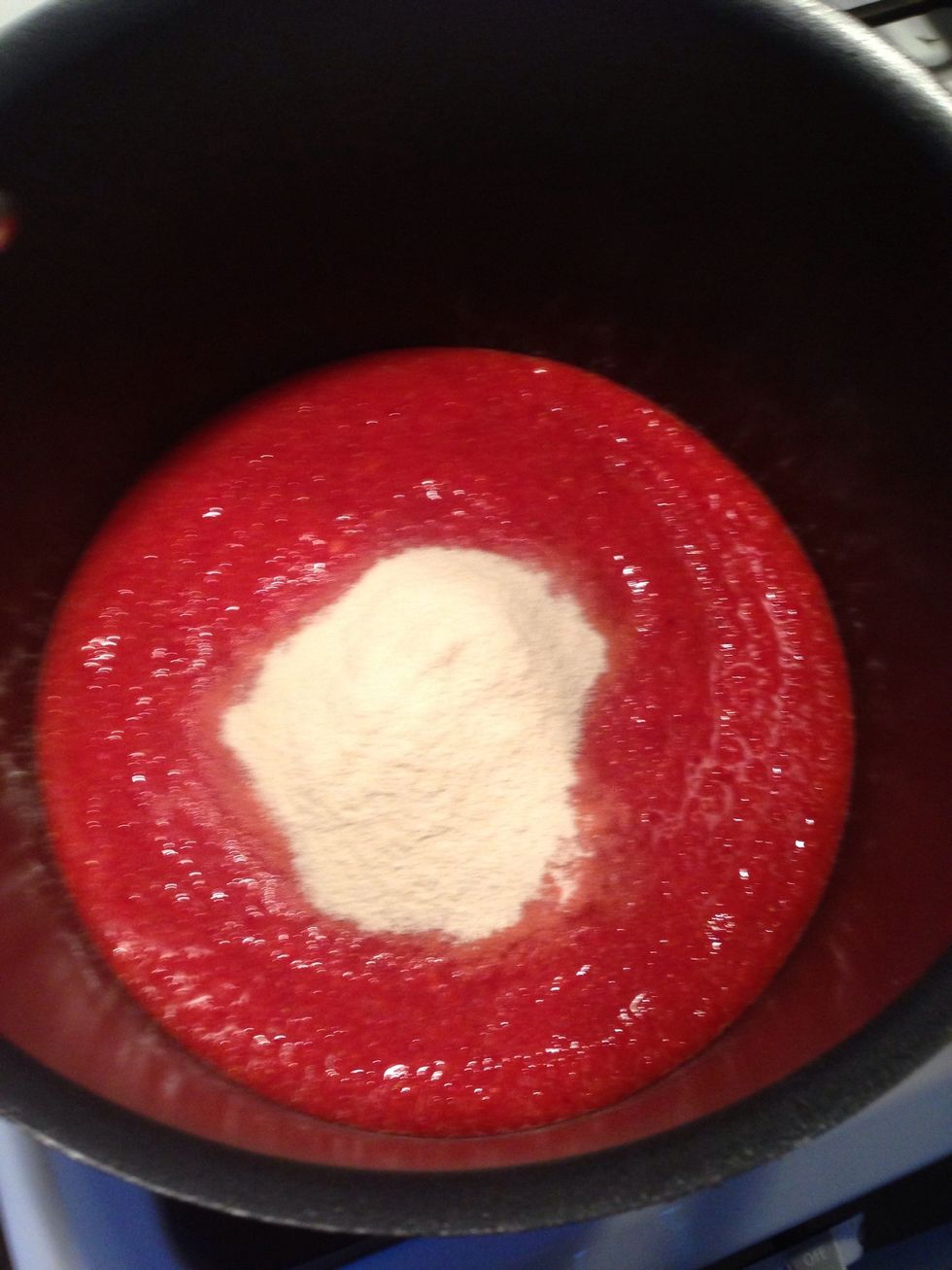 Pour the strawberries into a large pot and add the pectin (available at most grocery stores). Use less if you want runny jelly, use more if you like it thicker. I use 4.5 tablespoons.