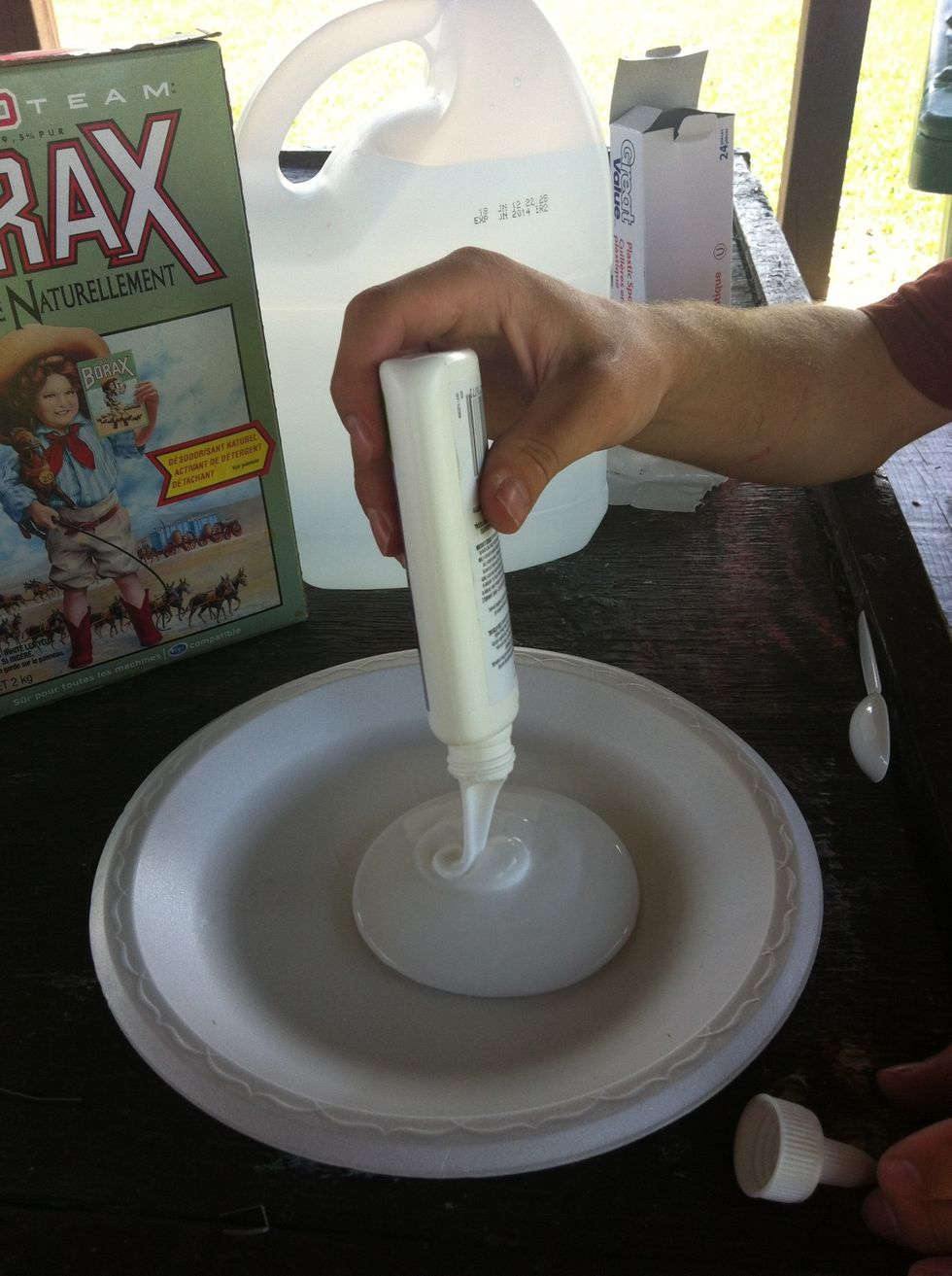 Pour the white glue onto a plate.