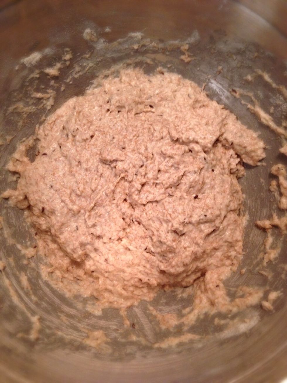 Pour the yeast in your flour mixture and use a wooden spoon to combine ingredients. You might need to add more warm water. The dough should be sticky, but not too liquidy.