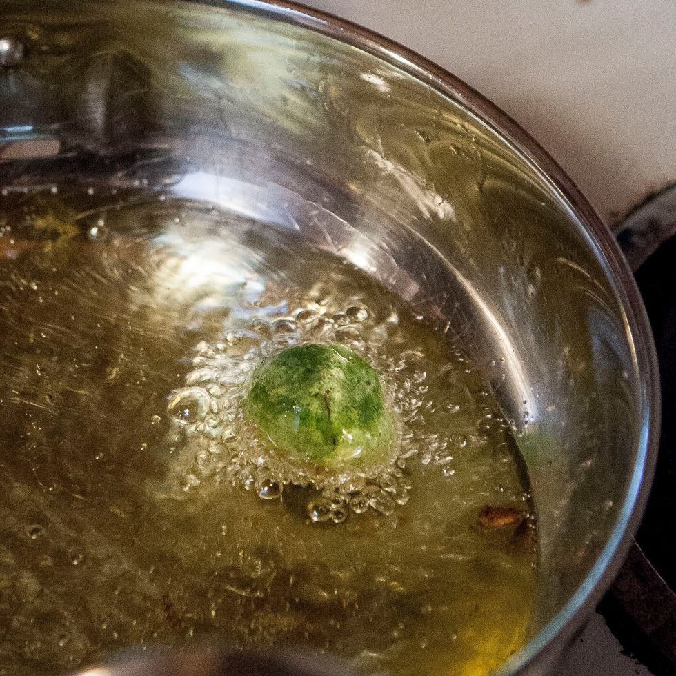 Pour vegetable oil into a small wok or kadhai. Fill it about 2 inches deep. Heat the oil and when it is hot drop the balls into it.