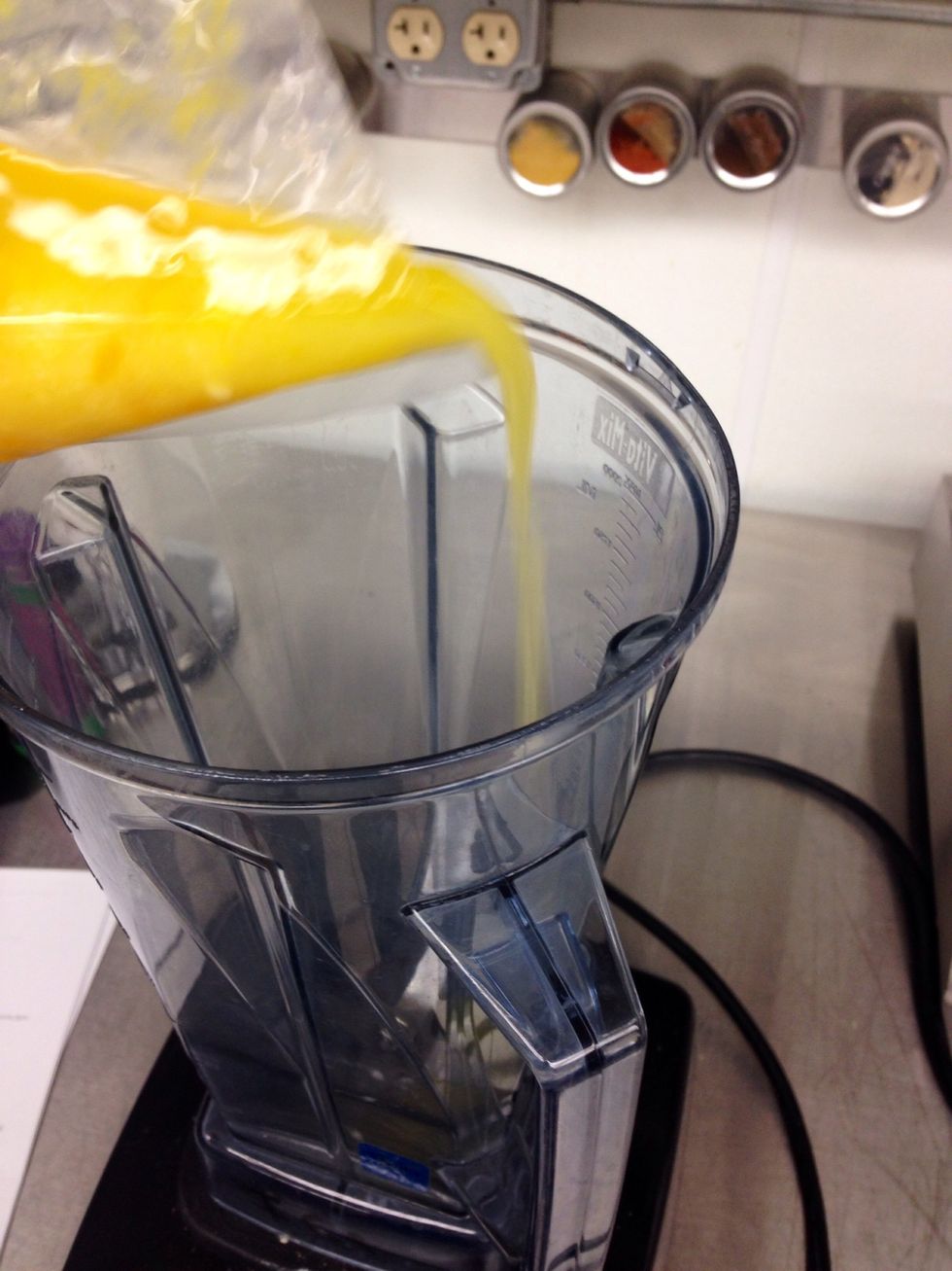 Pour warm curd from sous vide pouch into a blender