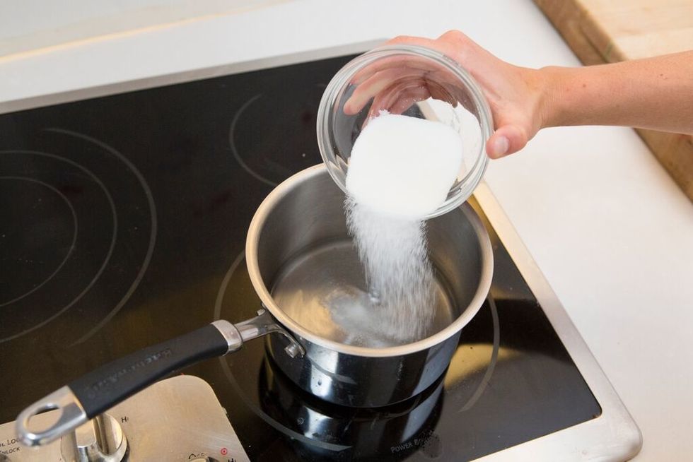 Pour water and sugar into a medium pot. Bring the water and sugar to a boil over medium to high heat until sugar dissolves.