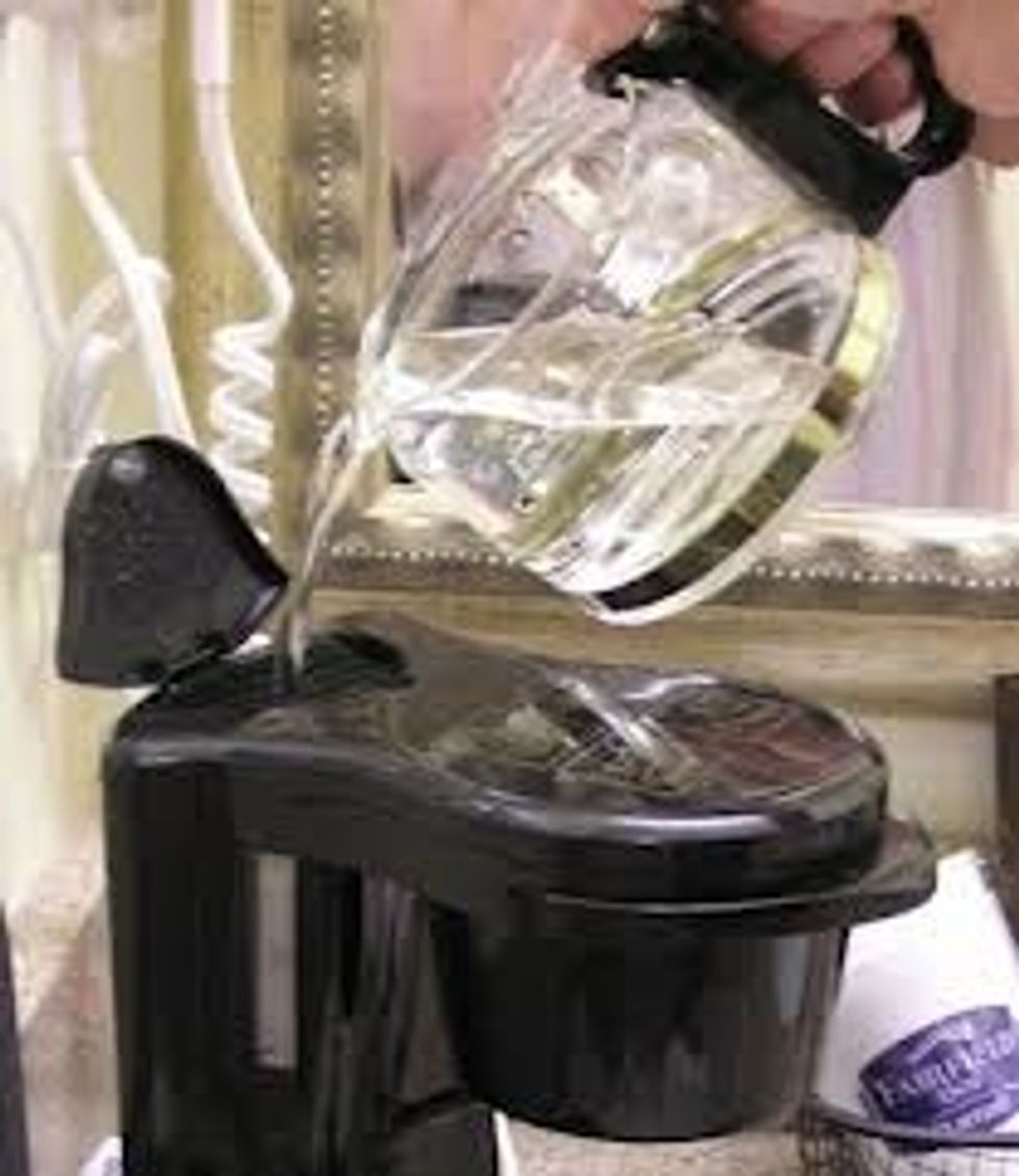 Pour water into the compartment on your coffee filter. Note the lines on the coffee maker. The ratio is 2 cups of water to 1 tablespoon of coffee. For 2 cups of coffee, pour the water to the line 4.