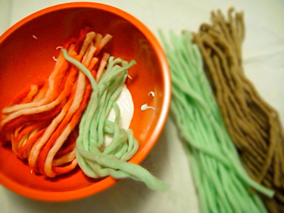 Pour white glue into clean bowl. Cut yarn into 7 inches long strings and combine with glue.