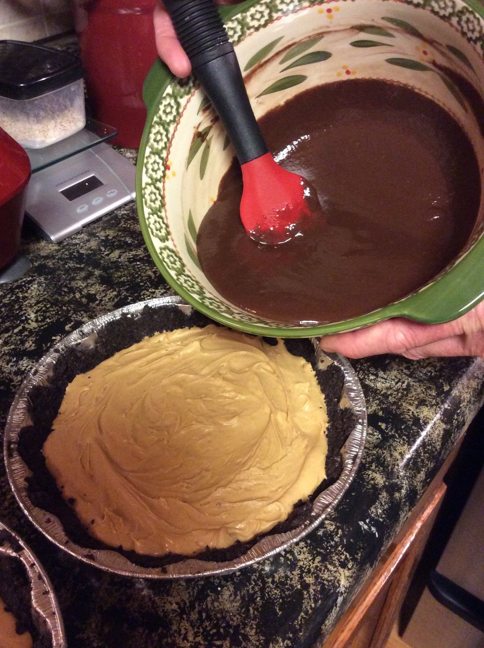 Pouring chocolate on top of the peanut butter filling and crust.