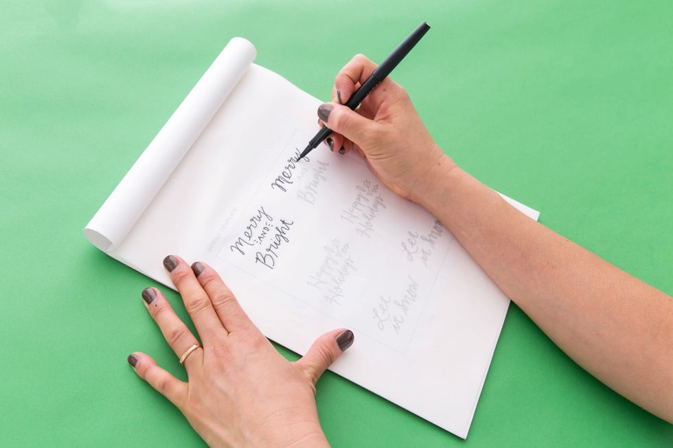 Practice tracing the holiday sayings and adding the fauxligraphy line on all of the downstrokes with the black pen.