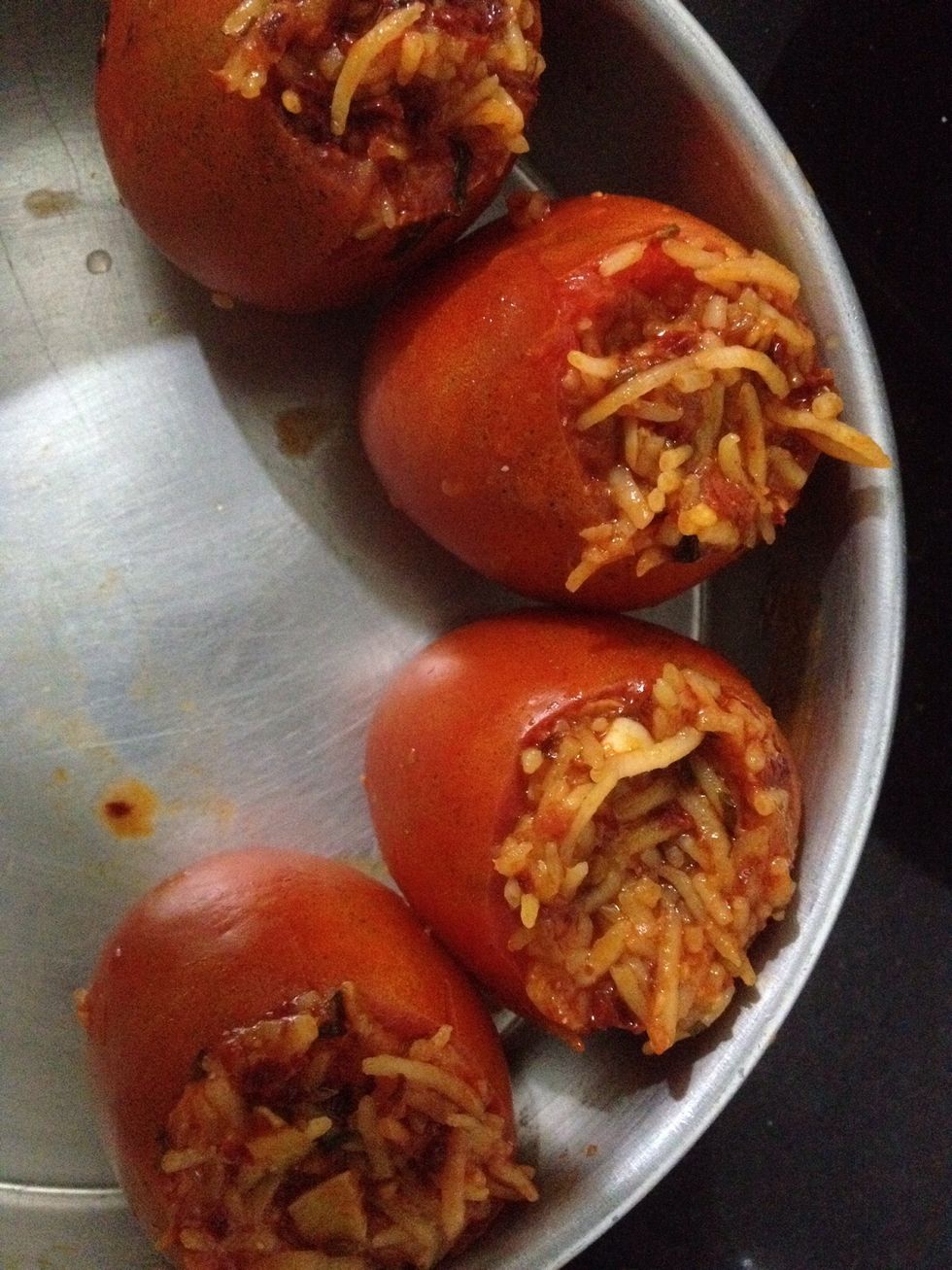 Pre heat the oven at 170 deg and then stuff the tomatoes with hot rice using spoon. Apply some olive oil on the outside ot tomatoes and put it in the oven