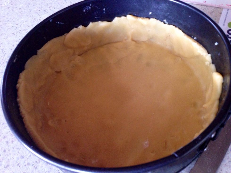 Preheat oven to 180\u00baC. Roll out the larger dough portion on a floured surface into a 24cm disc. Line a round 20cm springform pan with the pastry disc, to cover the base and about 2cm up the side.