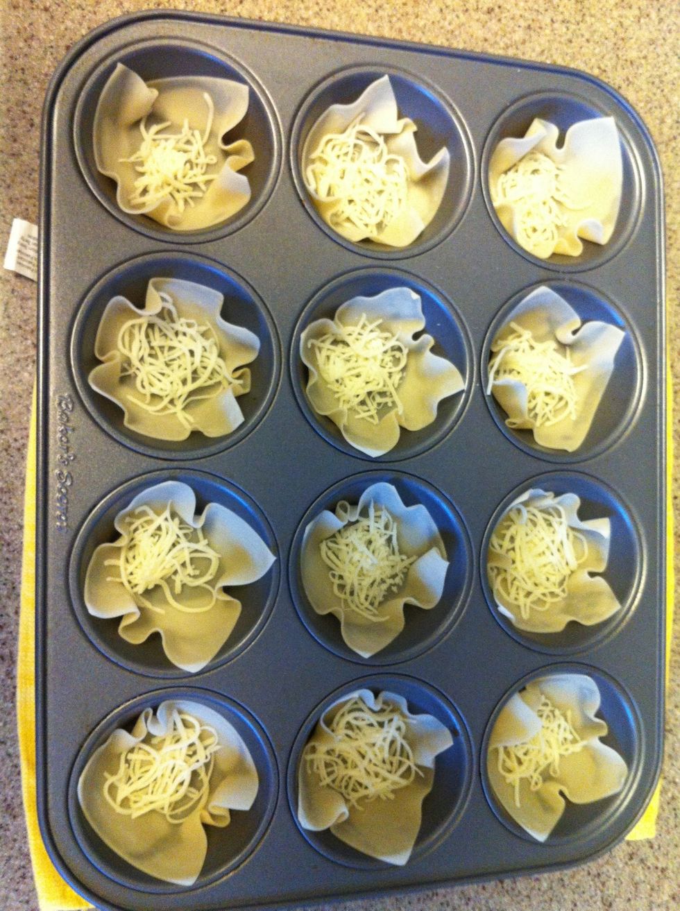Preheat oven to 400 degrees F. Grease muffin tins, put a wonton skins to each muffin cup and add a little sprinkle of cheese to the bottom. Then, Bake for about 3 minutes.