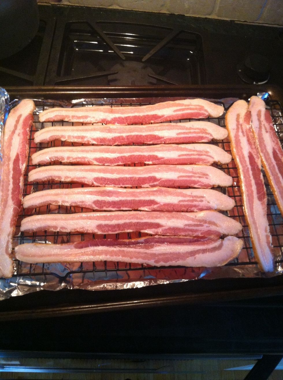 Preheat oven to 400 F. Line up bacon on cooling rack above a aluminum foil lined pan with edges. Cook 20 mins and check if crispy enough for your liking