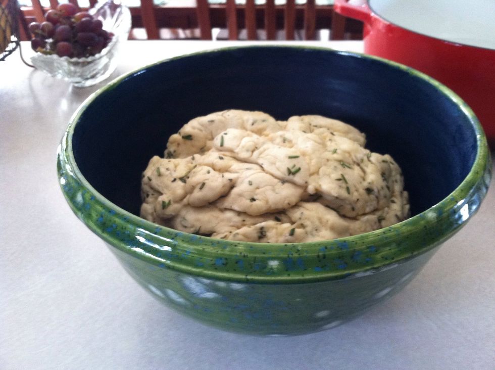 Preheat oven to 450\u00b0. Pour a tablespoon of olive oil in the pan. Punch down the dough and knead for a couple of minutes. Form into a smooth round and rub oil over the top.