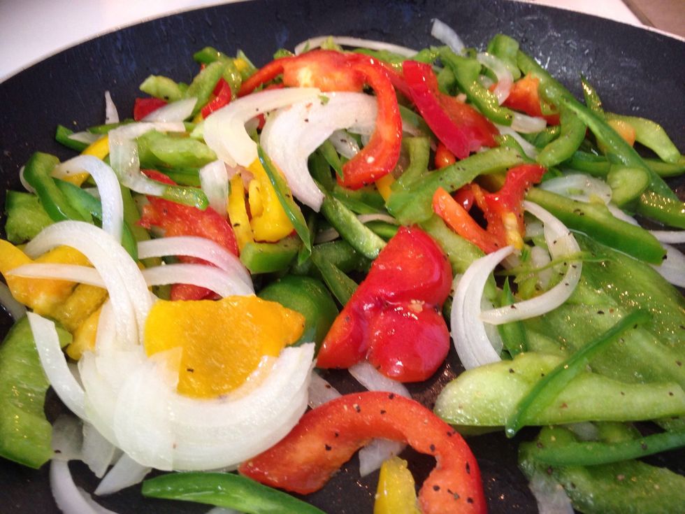 Preheat the olive oil in a large saut\u00e9e pan over medium heat. Place the peppers, onion, garlic into the hot oil and caramelize. Stir periodically. Add salt and pepper.