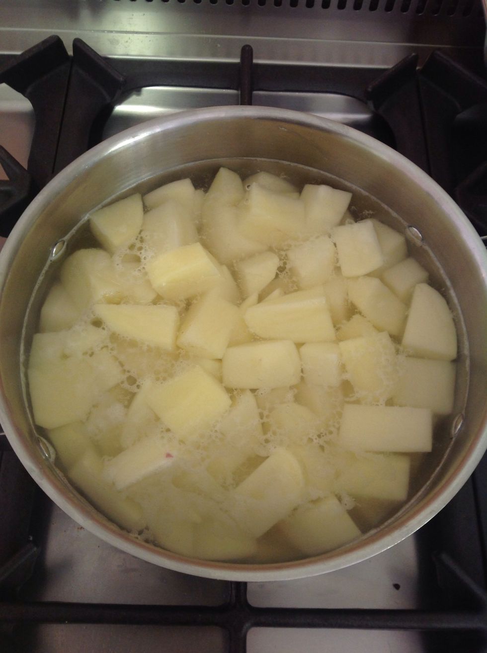 Preheat the oven to 200 Celsius degrees. Cut the potatoes into cubes and put it in a casserole filled with water. Boil it for few minutes. The potatoes should not be very soft but also not hard