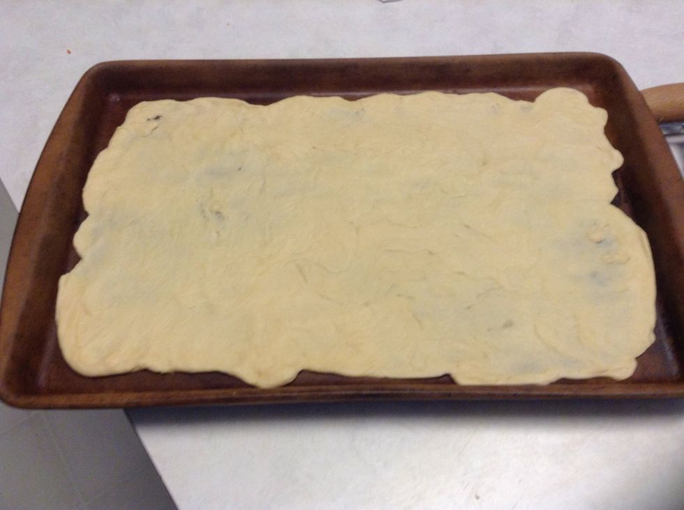 Preheat the oven to 375 degrees. Using the large pampered chef bar pan (15 1/2x10) , roll the dough out using the bakers roller to form pizza crust. Make sure u don't leave any holes in the dough.