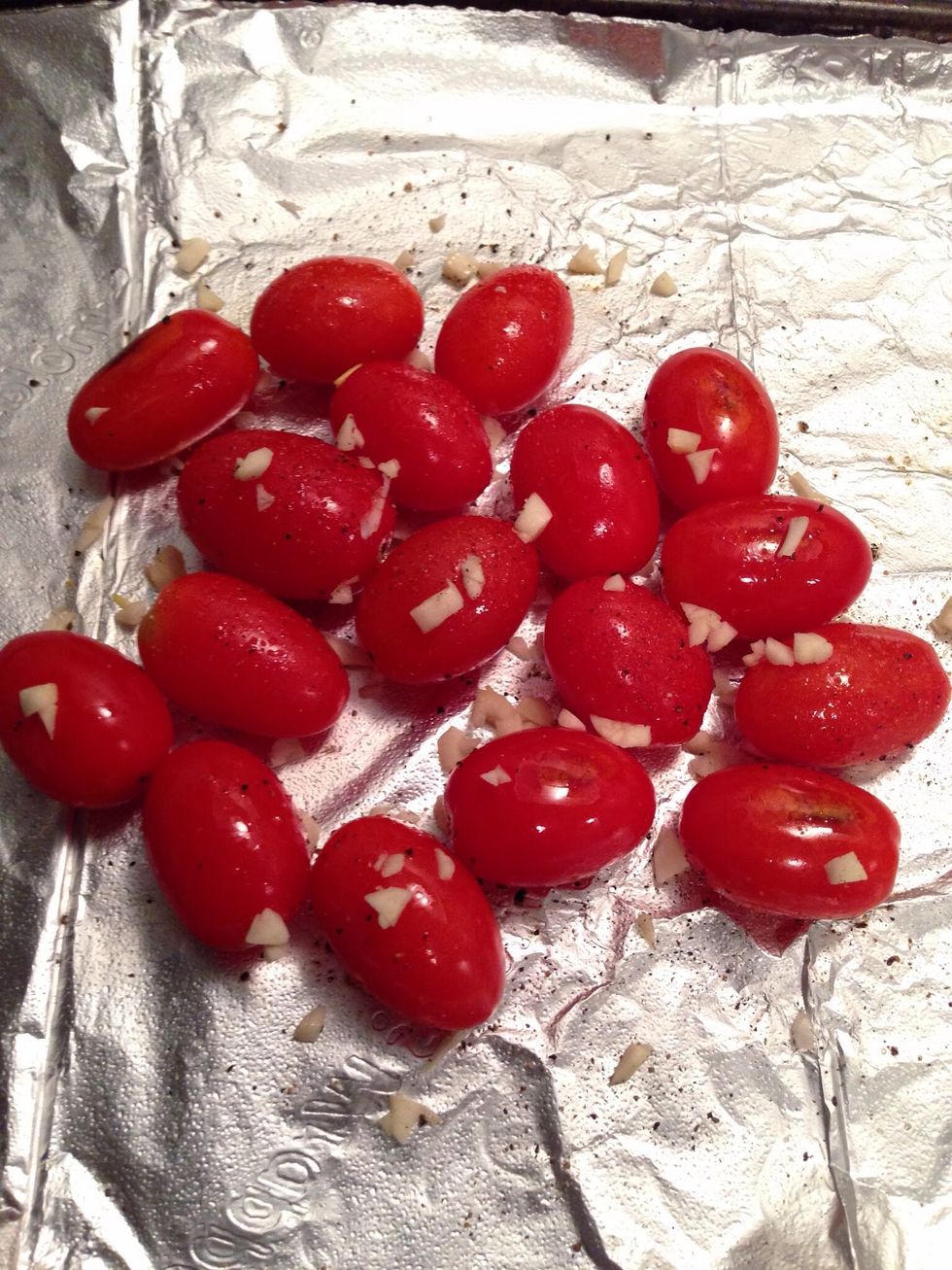 Preheat the oven to 400 degrees. Place the tomatoes  & garlic on a baking tray lined with foil. Drizzle with olive oil & season with sea salt & black pepper. Roast for 15-20 minutes.