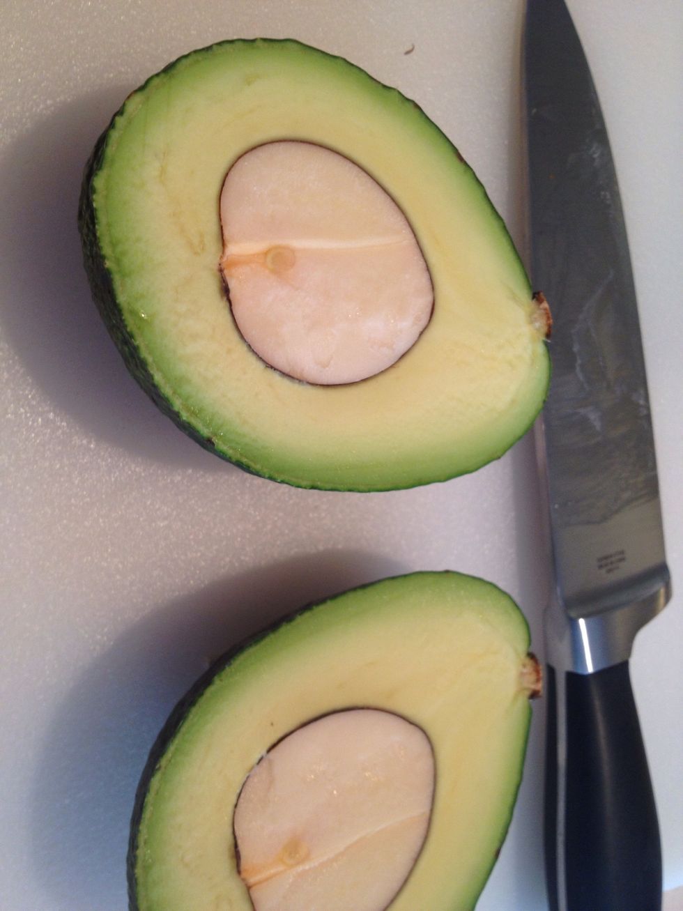 Preheat the oven to 475 degrees with a cast iron pan inside. Wash and halve the avocado.