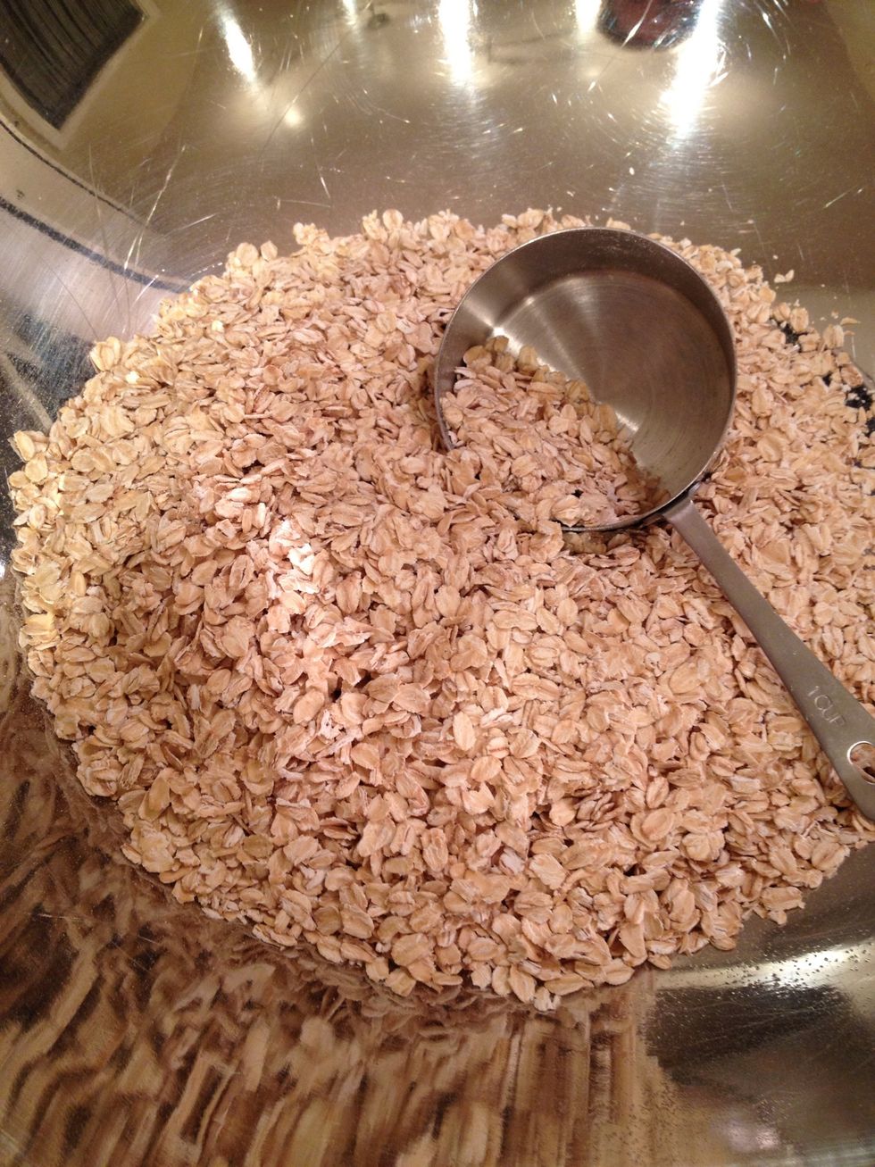 Preheat your oven to 325 degrees F. Put six cups of rolled oats into a very large bowl.