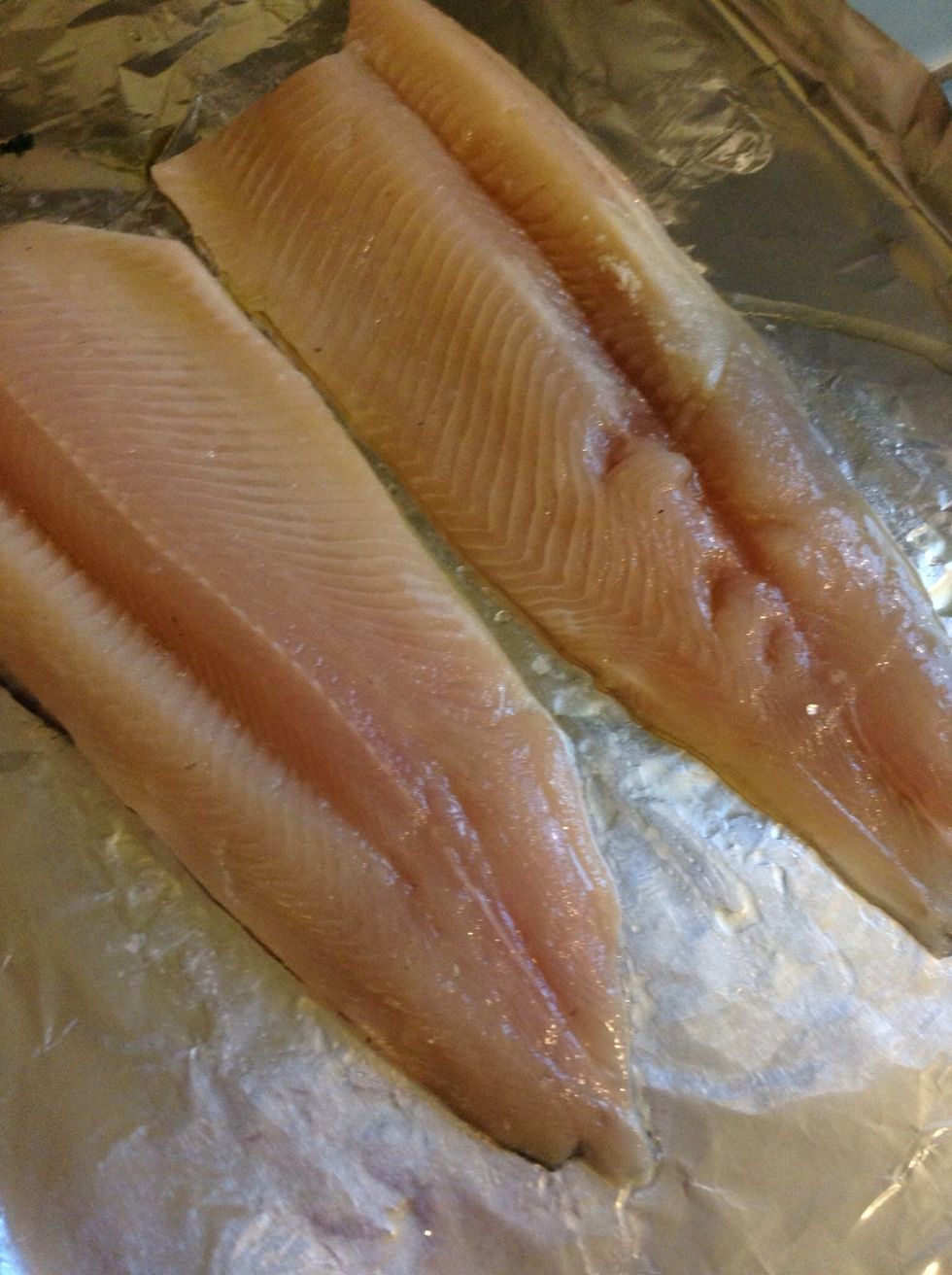 Preheat your oven to 450\u00b0F. Place your trout fish fillets, skin side down, on a foil covered cookie sheet.