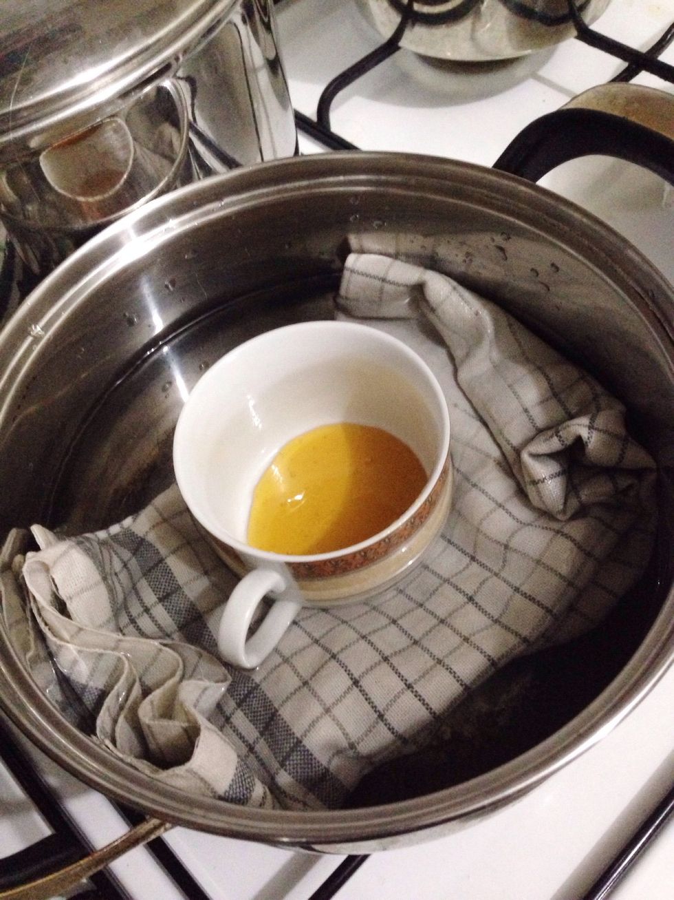 Prep a large pot. Layer the bottom with kitchen towel, fill it with water. There should be enough water to cover the bottom half of your ramekin. Just like in the picture. Bring water to simmer