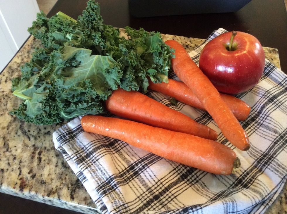 Prep juicing fruits and veggies. Start with the carrots, kale and apple.