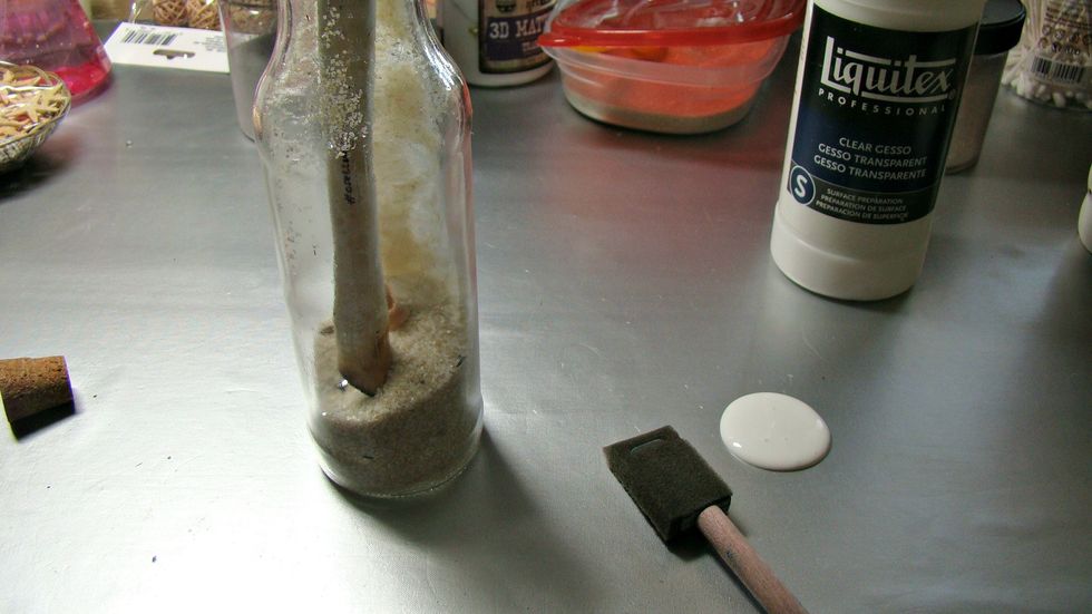 Prep your glass bottle for sprays and paints by priming it with clear gesso leaving the area on the bottle that shows the message inside the bottle, You will not be applying mediums to this area.