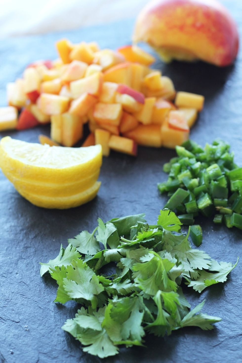 Prep your salsa ingredients: chop 2 peaches, mince \u00bd to 1 whole jalapeno, gather a \u00bc cup of cilantro leaves, and squeeze 1 tablespoon of lemon juice.