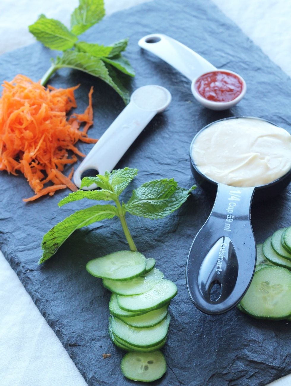 Prep your vegetable toppings: peel and shred one carrot, thinly slice a quarter of an English cucumber, and wash and tear off a \u00bc cup of mint leaves.
