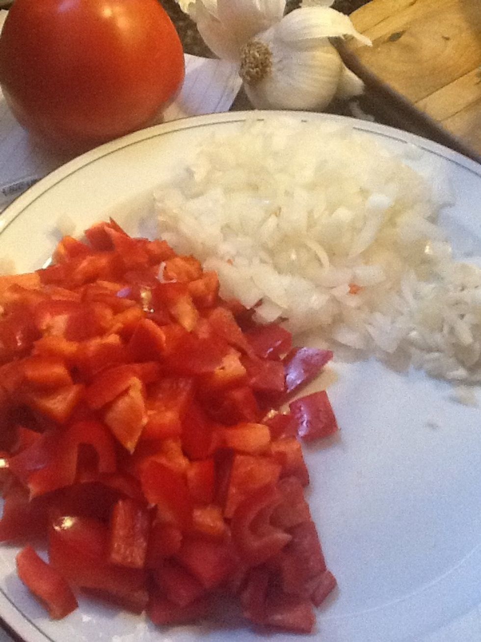 Prepara los ingredientes: corta las cebollas, los ajos y los pimientos morrones