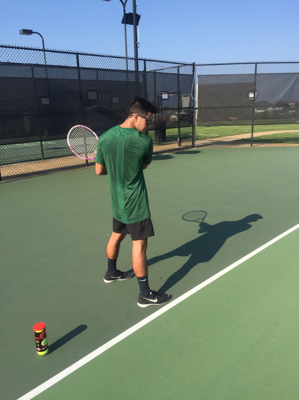 Preparation: rotate the hips and shoulders to place the side of the body towards the net. Bring the racquet back to shoulder level while gripping it with both hands.