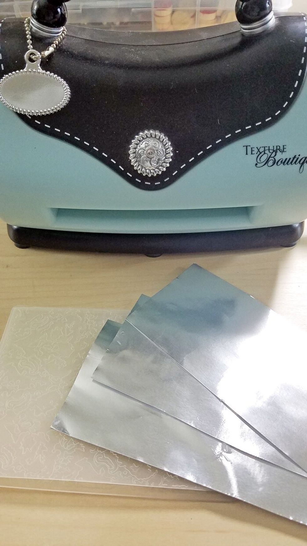 Prepare adhesive metal sheets by embossing with your favorite embossing folder.
