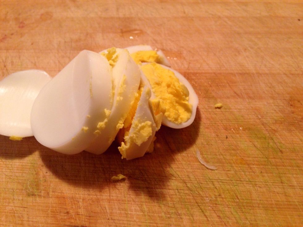 Prepare eggs by slicing and use A large knife to transfer into the pot. Ideally we don't want to dice the eggs because it's not a 'background singer' so to speak. It's best left as shown here.
