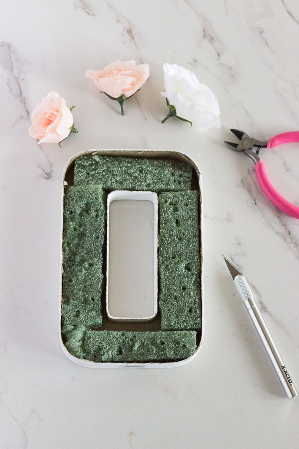 Prepare floral foam, cut up the floral foam in various pieces to make it fit instead the \u201cO.\u201d You might want to glue gun the floral foam to the inside of the \u201cO" so that the pieces don't fall out.