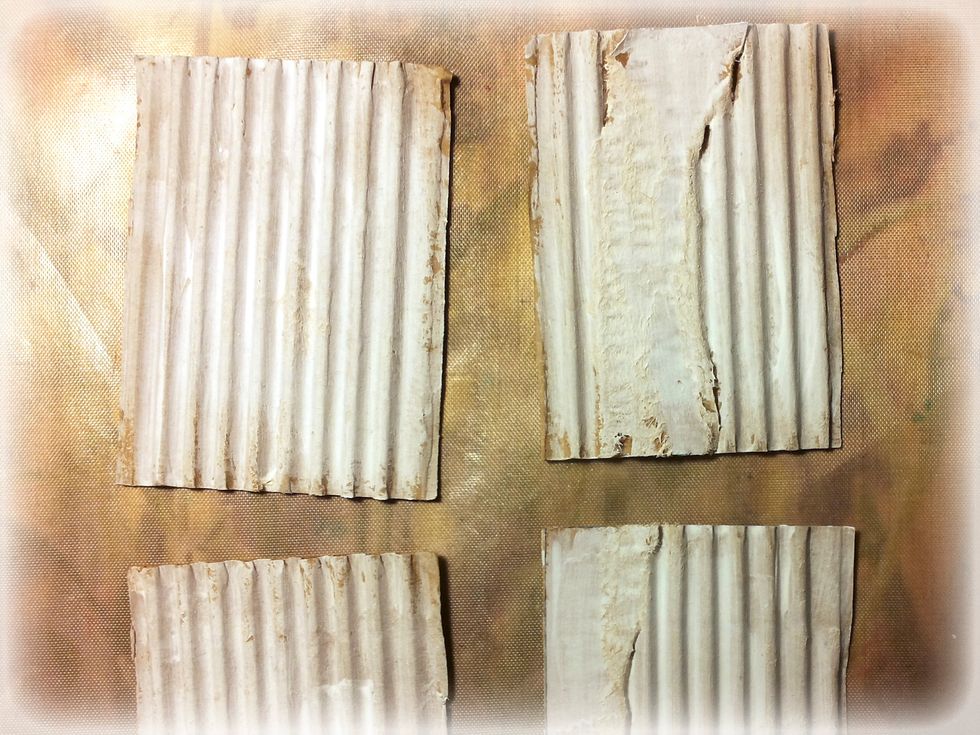 Prepare some cardboard. Distress the surface and add gesso.
