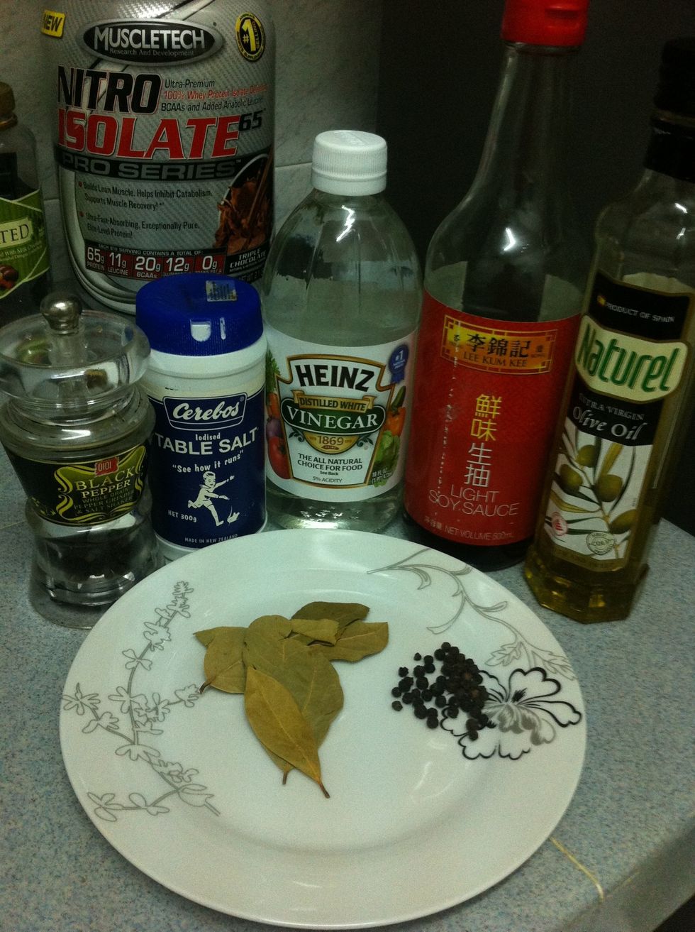 Prepare the ingredients. Olive oil, light soy sauce, vinegar, black peppercorn, dried bay leaves, ground blackpepper and salt