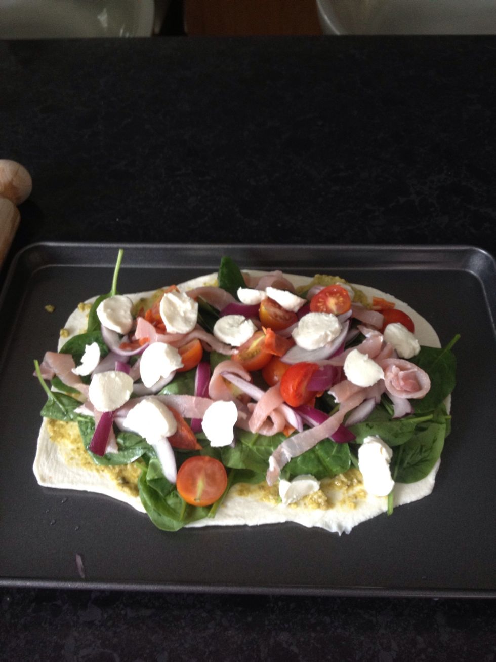 Prepare the other components - tomatoes, mozzarella and red onion, and wash the spinach in a colander! Starting with the spinach, dress the pastry on top of the pesto, then add the other components