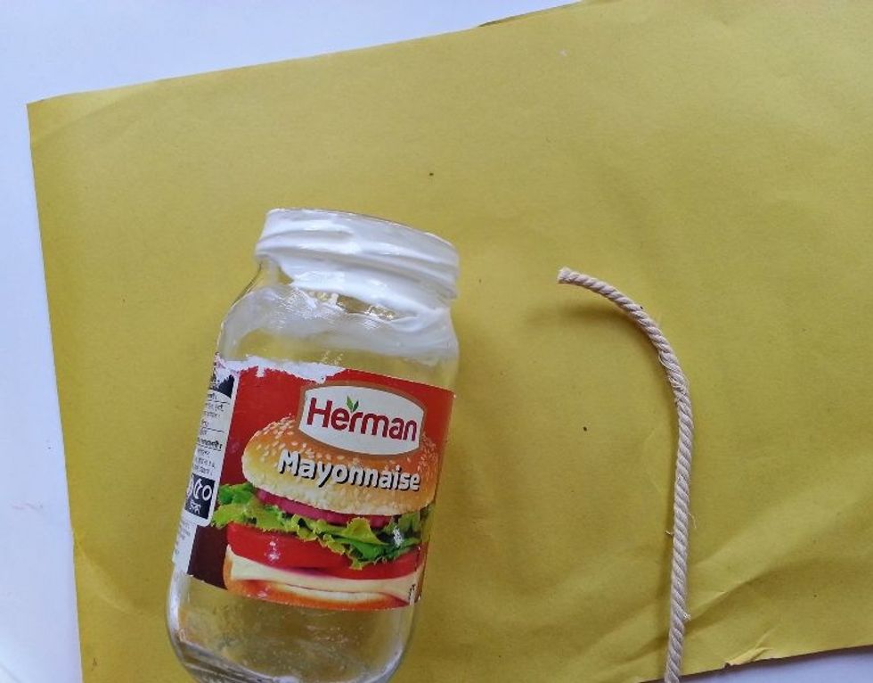 Prepare the twine, making sure there are no tangles on the twine bundle. Let's start from the top. Apply craft glue around the jar\u2019s top.
