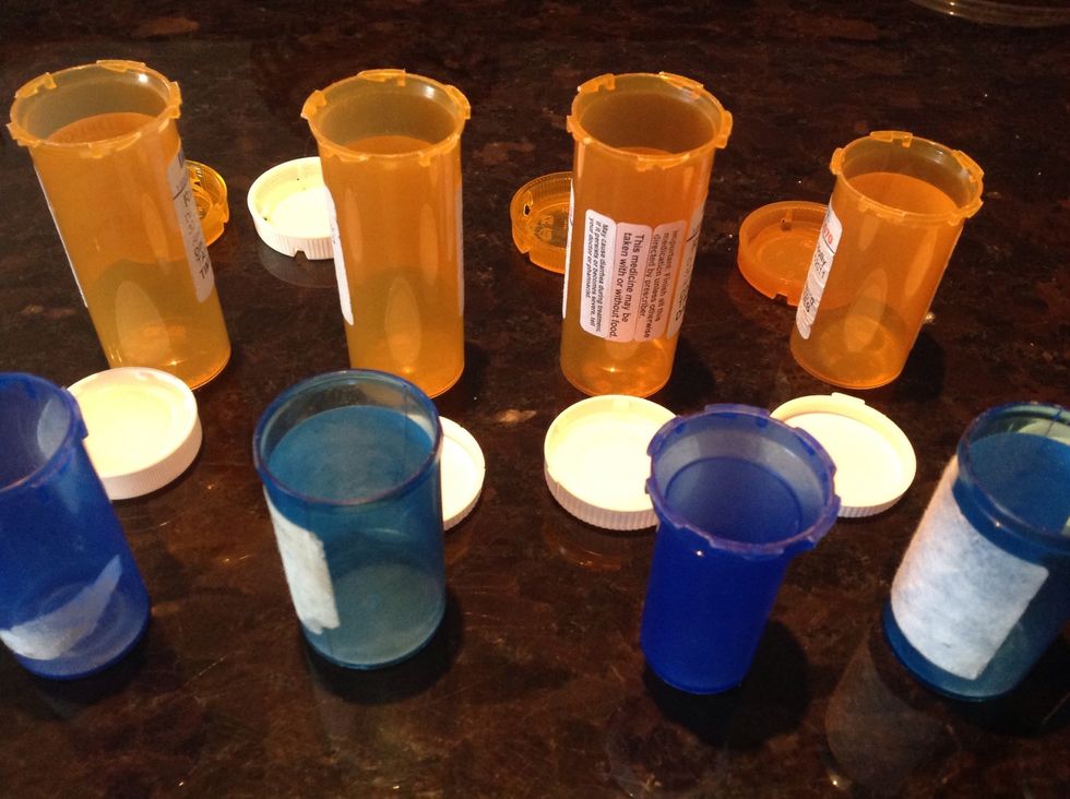 Prepare your cleaned empty medicine bottles by colour for each family member by lining them up in a row with opened caps alongside.